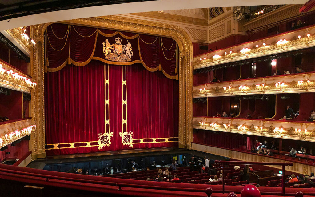 Royal Opera House interior view with red velvet curtains and ornate gold details.