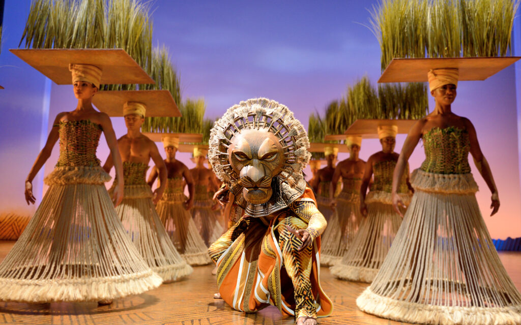 Lion King stage performance with Simba and dancers.